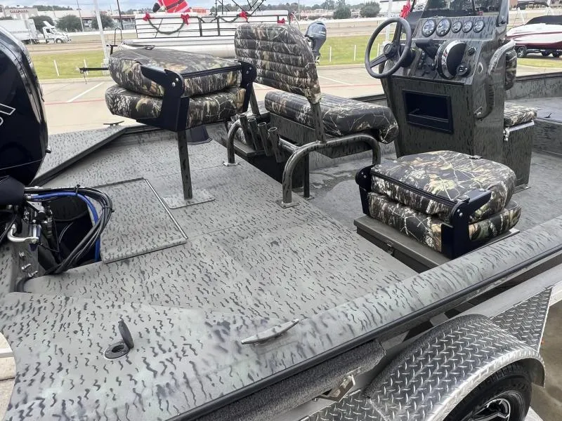 Slide: The Image of 2023 War Eagle 961 Blackhawk boat interior with camo seats and steering console. - 12