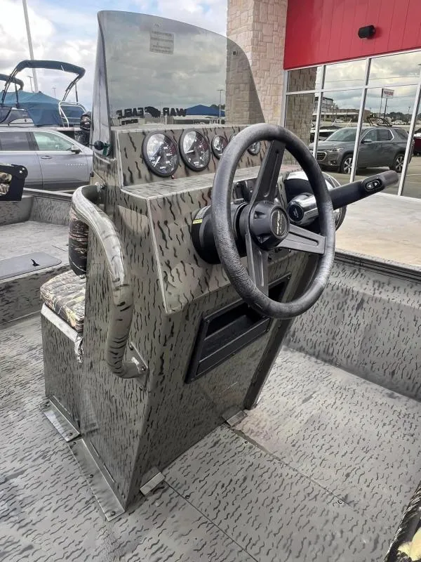 Slide: The Image of 2023 War Eagle 961 Blackhawk boat console with steering wheel and gauges. - 14
