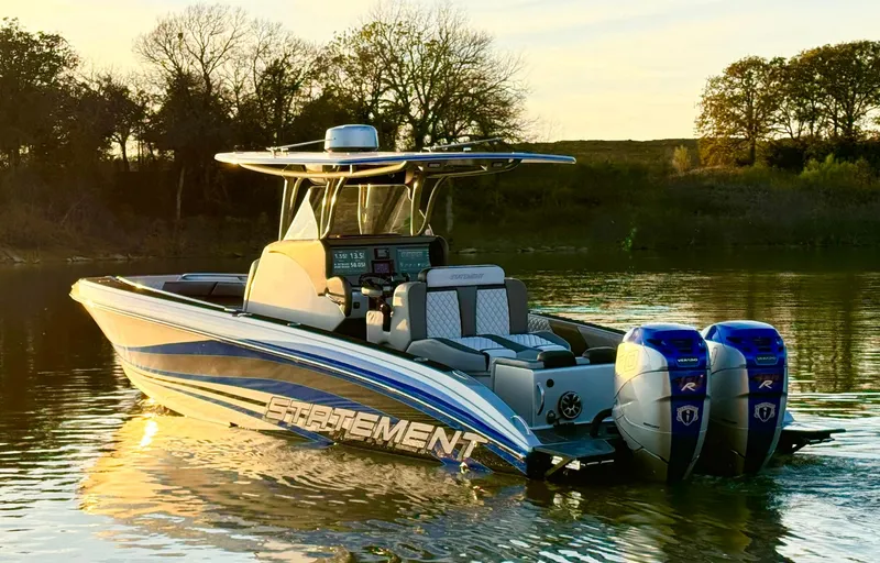 Slide: The Image of 2020 Statement 350 Open boat with dual engines on a serene lake at sunset. - 2