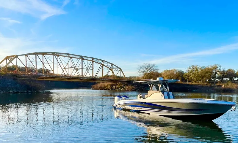 Slide: The Image of 2020 Statement 350 Open boat on calm river near a bridge. - 37