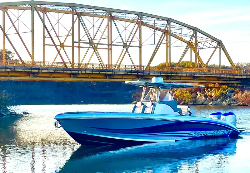 Slide: The Image of 2020 Statement 350 Open boat on water near a metal bridge. - 40