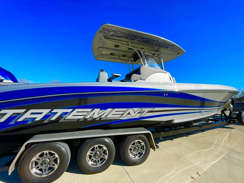 Slide: The Image of 2020 Statement 350 Open boat on trailer, blue and white design, clear sky background. - 8