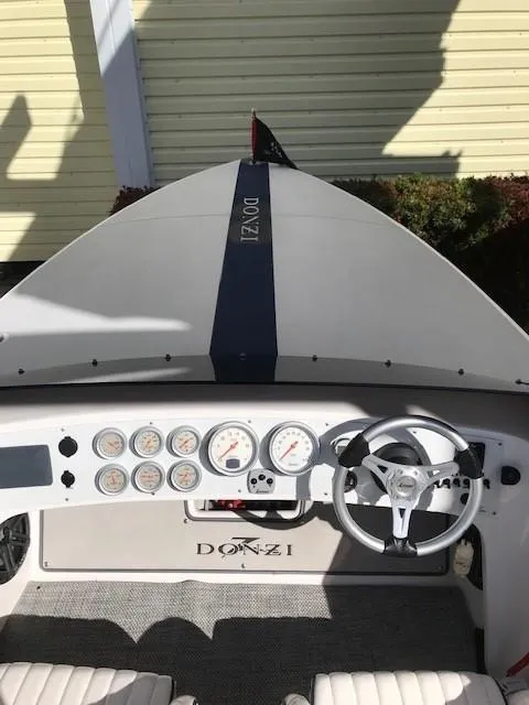 Slide: The Image of 2018 Donzi 22 Classic boat dashboard with gauges and steering wheel. - 12