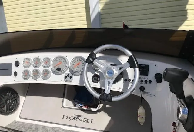 Slide: The Image of 2018 Donzi 22 Classic boat dashboard with steering wheel and gauges. - 13