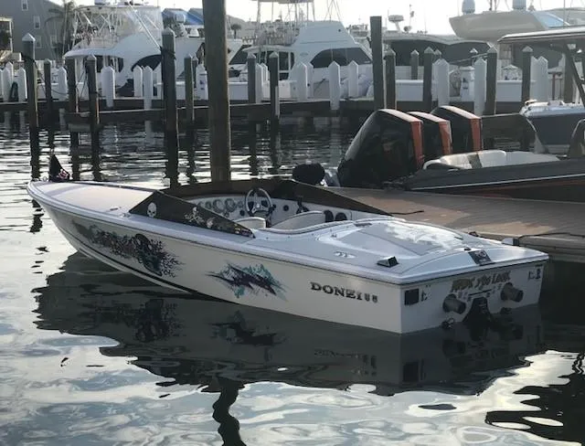 Slide: The Image of 2018 Donzi 22 Classic speedboat docked at marina with custom graphics. - 22