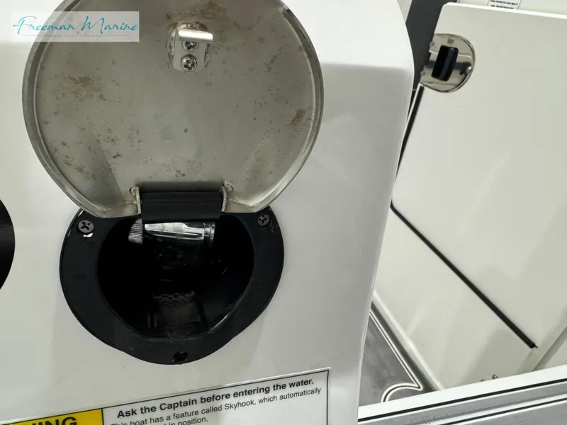 Slide: The Image of 2022 Blackfin 332 CC boat detail with open hatch and safety warning label. - 28