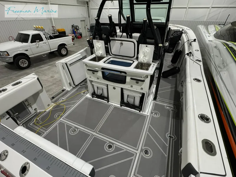 Slide: The Image of 2022 Blackfin 332 CC boat interior with modern seating and equipment in a garage setting. - 29
