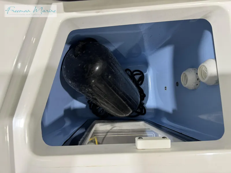 Slide: The Image of 2022 Blackfin 332 CC storage compartment with black fender and ropes. - 32