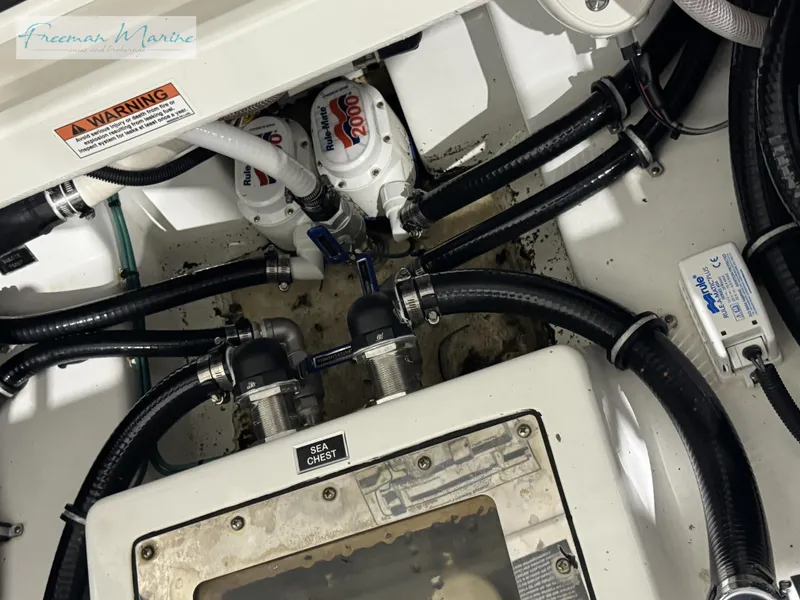 Slide: The Image of 2022 Blackfin 332 CC boat engine compartment with hoses and pumps. - 35