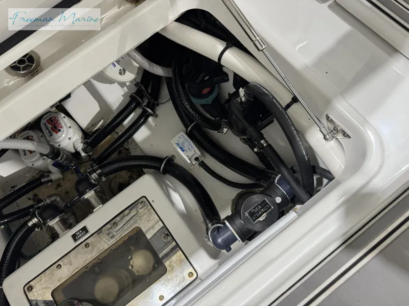 Slide: The Image of 2022 Blackfin 332 CC boat engine compartment with hoses and mechanical components. - 36