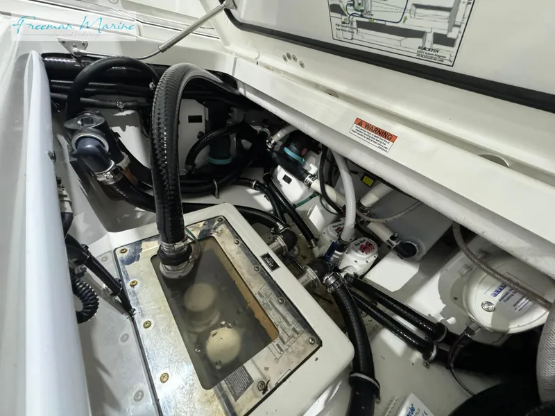 Slide: The Image of 2022 Blackfin 332 CC engine compartment with hoses and mechanical components. - 38