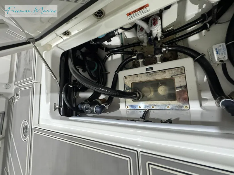 Slide: The Image of 2022 Blackfin 332 CC boat engine compartment with visible hoses and components. - 39