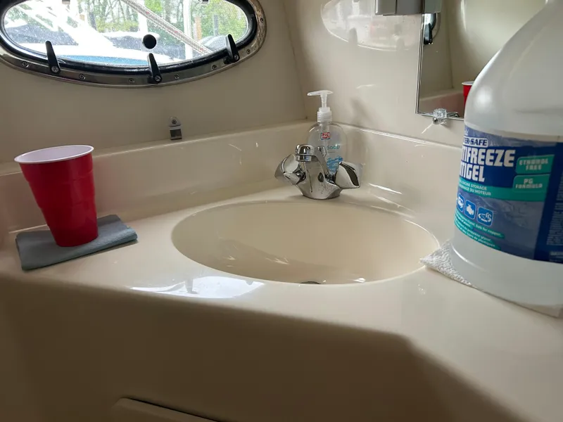 Slide: The Image of 1997 Tiara Yachts 3500 Express bathroom sink with red cup and antifreeze bottle. - 19
