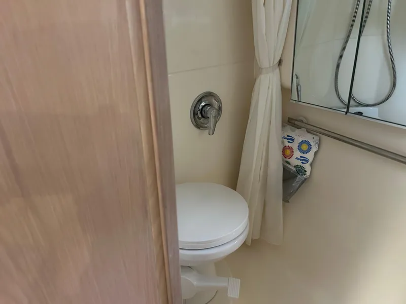 Slide: The Image of 1997 Tiara Yachts 3500 Express bathroom with toilet and shower curtain. - 20