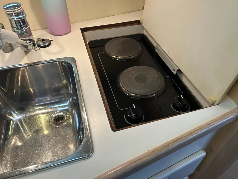 Slide: The Image of 1997 Tiara Yachts 3500 Express kitchen with sink and two-burner stove. - 24