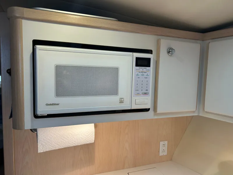 Slide: The Image of Microwave in 1997 Tiara Yachts 3500 Express kitchen area, mounted under white cabinets. - 25