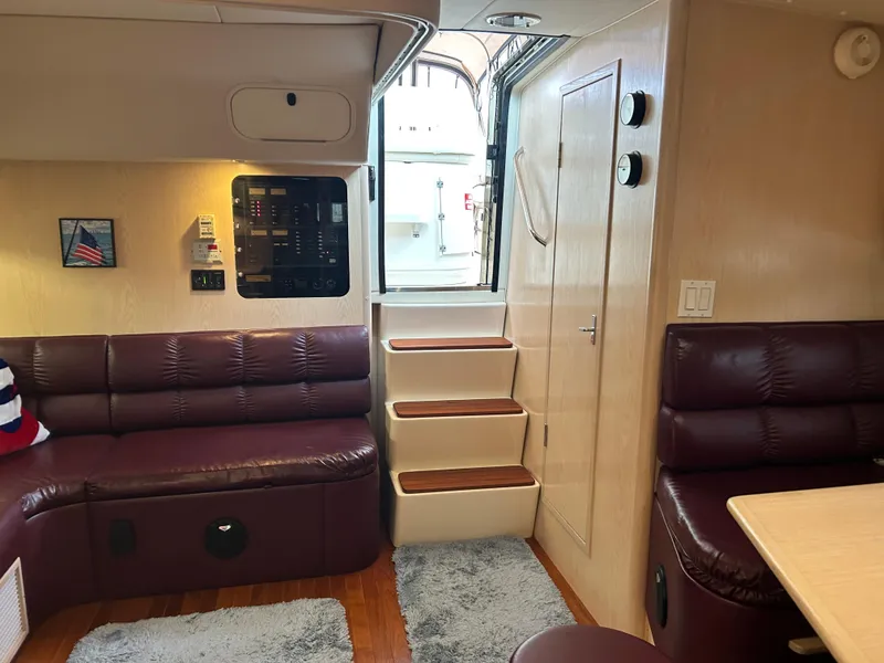 Slide: The Image of Interior of 1997 Tiara Yachts 3500 Express with maroon seating and wooden steps. - 27