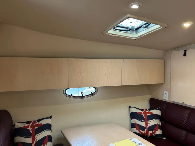 Slide: The Image of 1997 Tiara Yachts 3500 Express cabin interior with nautical-themed cushions and overhead storage. - 29