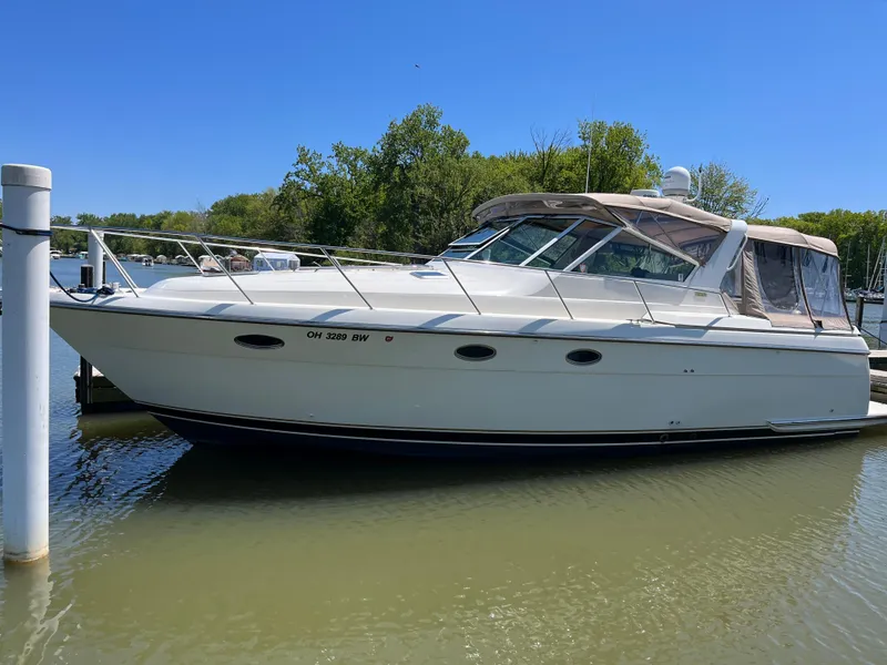 Slide: The Image of 1997 Tiara Yachts 3500 Express docked in a serene marina setting. - 4