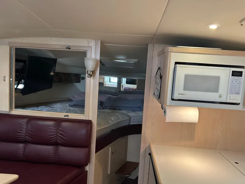 Slide: The Image of Interior of 1997 Tiara Yachts 3500 Express with bed, microwave, and seating area. - 49