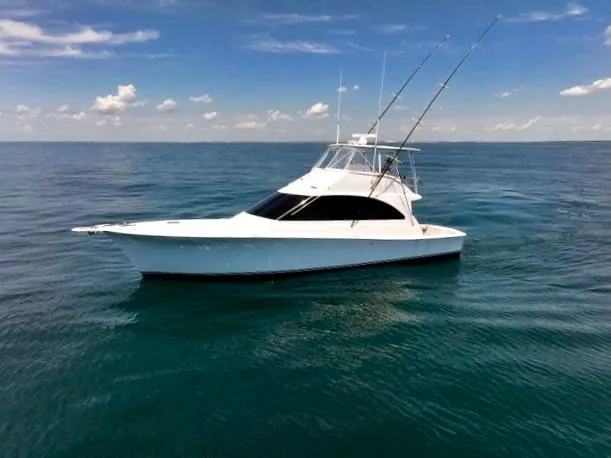 The Image of 2001 Ocean 52 Convertible yacht on calm ocean waters under a clear sky. - 0
