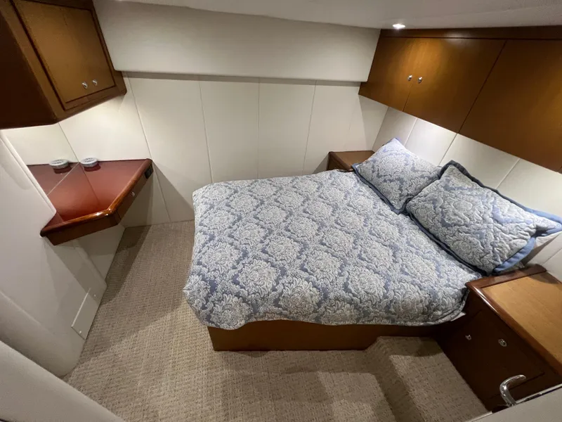 Slide: The Image of Cozy bedroom in 2001 Ocean 52 Convertible yacht with elegant bedding and wood accents. - 25