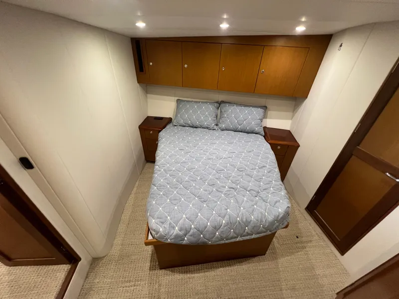 Slide: The Image of Cozy bedroom in 2001 Ocean 52 Convertible yacht with wooden cabinets and soft lighting. - 29