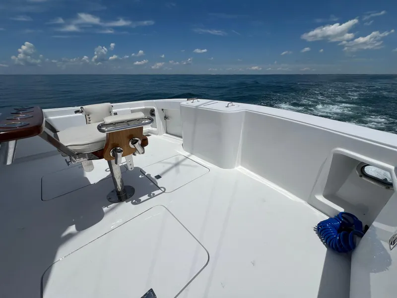 Slide: The Image of Ocean 52 Convertible 2001 boat deck with fishing chair, ocean view, and clear sky. - 42