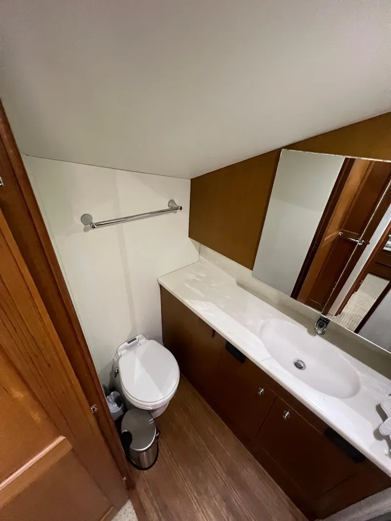 Slide: The Image of Bathroom interior of 2001 Ocean 52 Convertible yacht, featuring sink and toilet. - 48