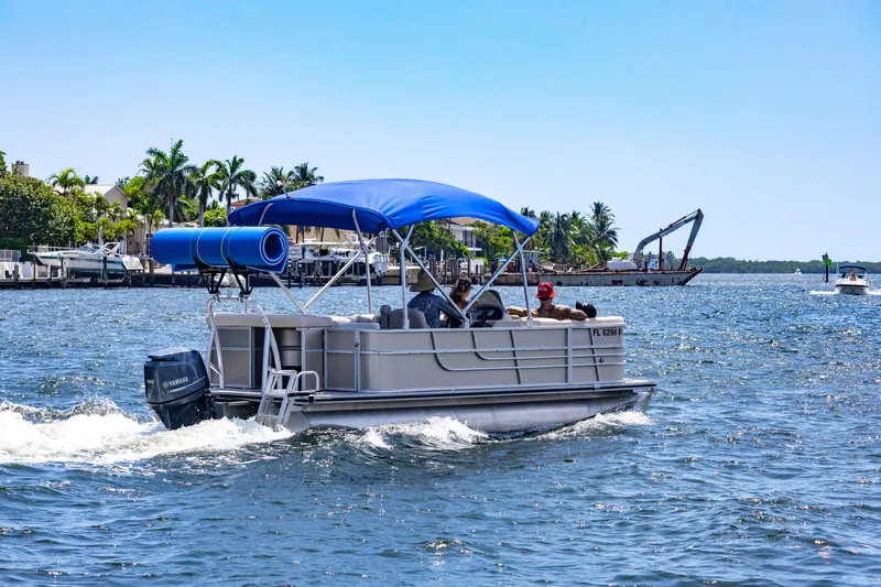 The Image of 2016 Starcraft 206 Sundeck boat cruising on a sunny day with blue canopy. - 1