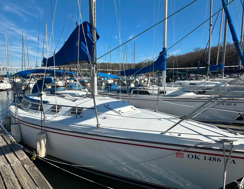 Slide: The Image of 1988 Catalina 30 sailboat docked at marina with blue sails. - 1