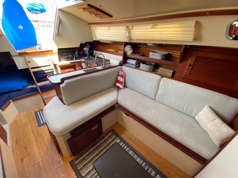 Slide: The Image of Interior of 1988 Catalina 30 sailboat with cozy seating and kitchen area. - 15