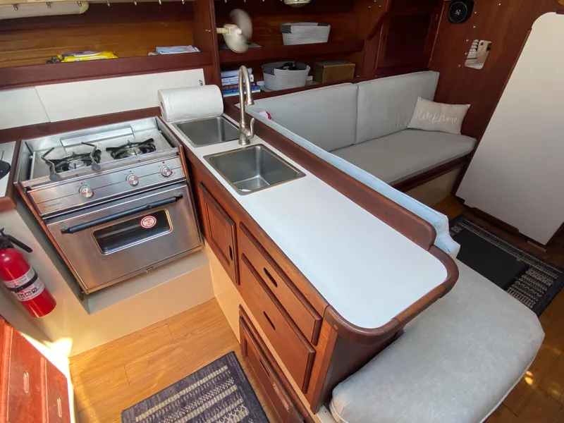 Slide: The Image of Interior of 1988 Catalina 30 sailboat with kitchen and seating area. - 18