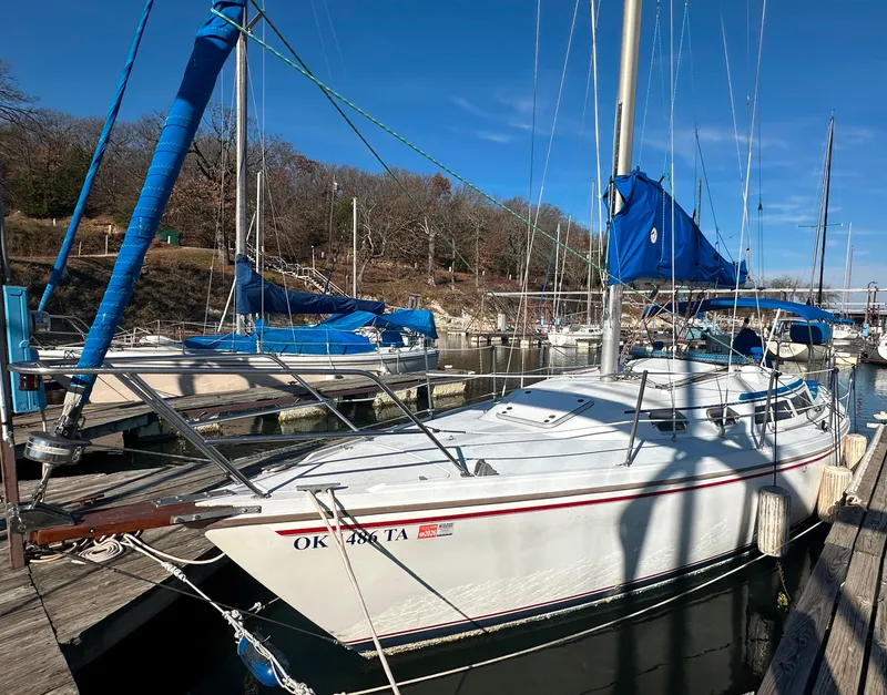 Slide: The Image of 1988 Catalina 30 sailboat docked at marina with blue sails. - 2