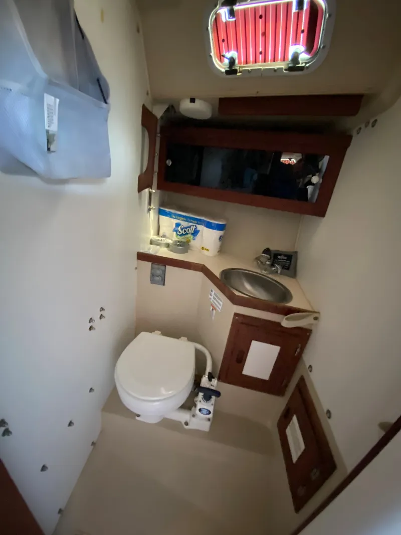 Slide: The Image of 1988 Catalina 30 boat bathroom with toilet, sink, and storage. - 20