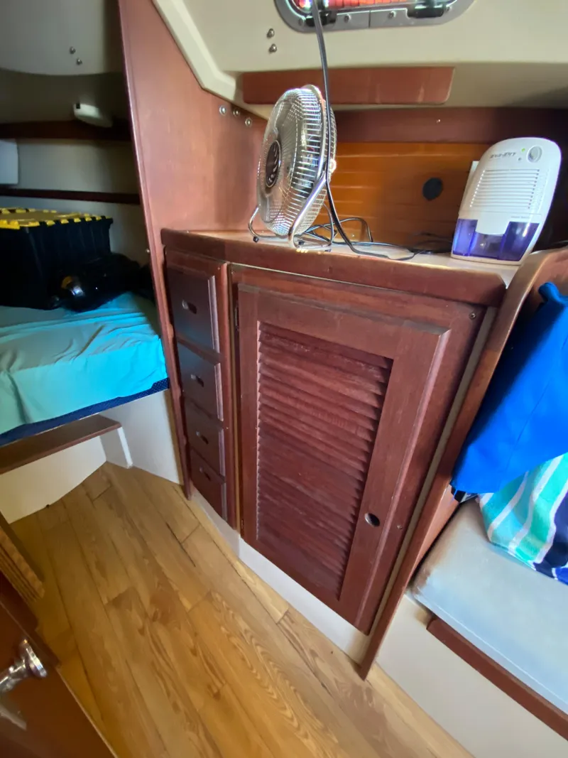 Slide: The Image of Interior of 1988 Catalina 30 sailboat with wooden cabinetry and compact fan. - 22
