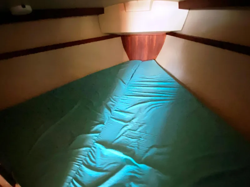 Slide: The Image of Interior cabin of a 1988 Catalina 30 sailboat with teal bedding. - 23