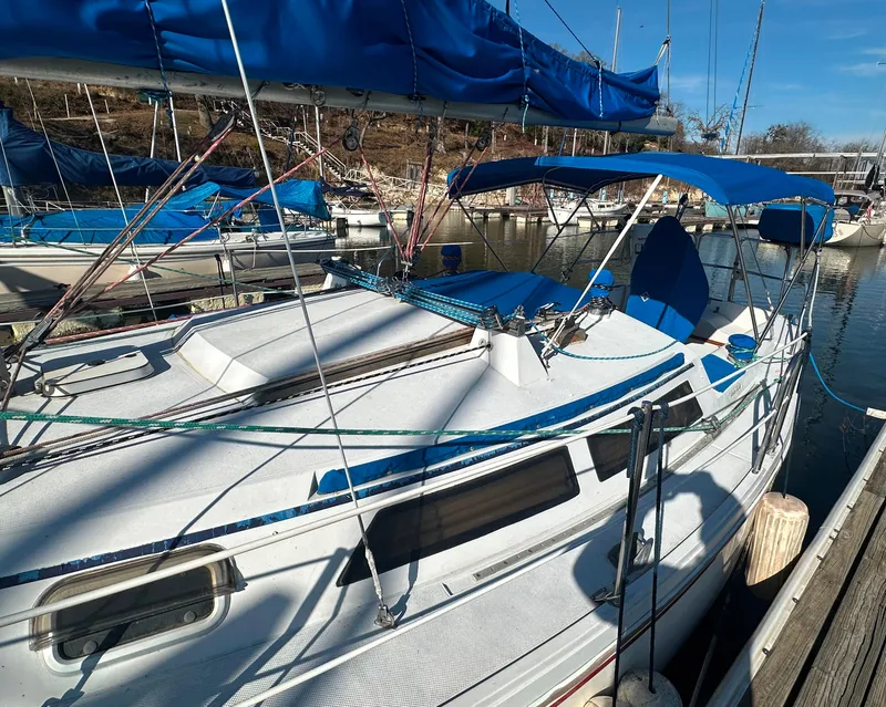 Slide: The Image of 1988 Catalina 30 sailboat docked, featuring blue canvas covers and rigging. - 3