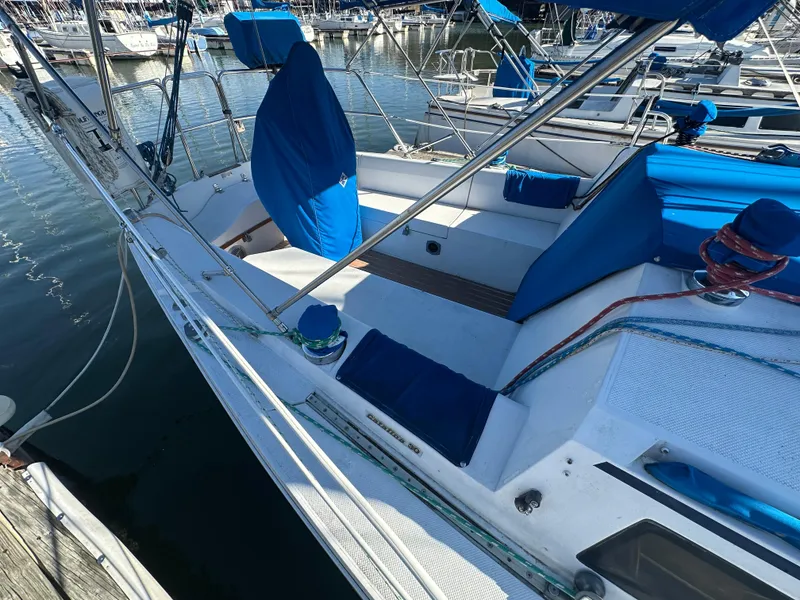 Slide: The Image of 1988 Catalina 30 sailboat with blue covers docked at marina. - 5