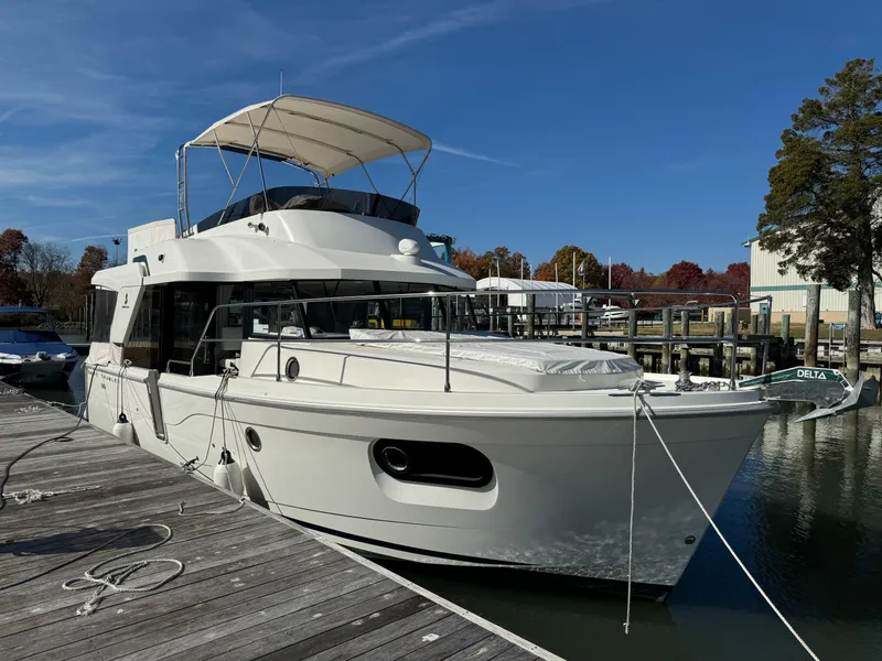 Slide: The Image of 2023 Beneteau Swift Trawler 35 docked at marina under clear blue sky. - 1