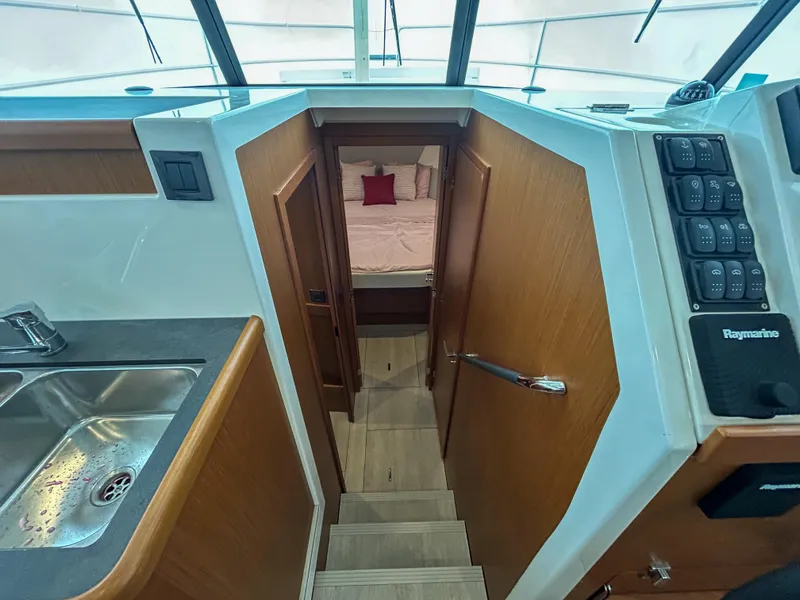 Slide: The Image of Interior view of 2023 Beneteau Swift Trawler 35, featuring stairs and cozy cabin. - 10