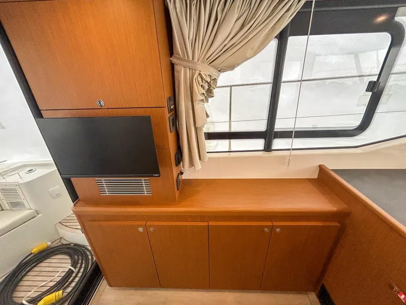 Slide: The Image of 2023 Beneteau Swift Trawler 35 interior with wood cabinetry and window view. - 13