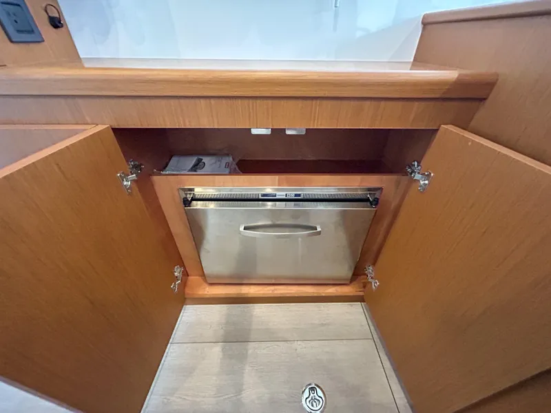 Slide: The Image of 2023 Beneteau Swift Trawler 35 interior with wooden cabinetry and built-in stainless steel appliance. - 14