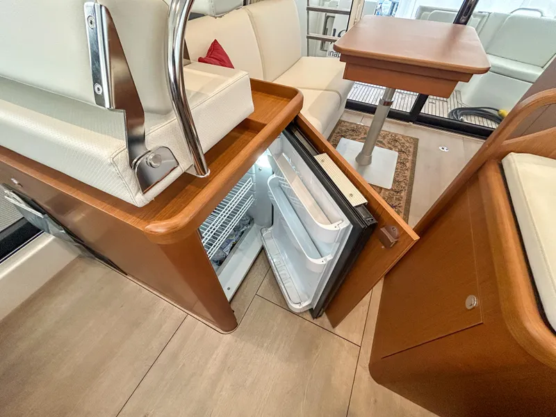 Slide: The Image of 2023 Beneteau Swift Trawler 35 interior with open fridge and seating area. - 15