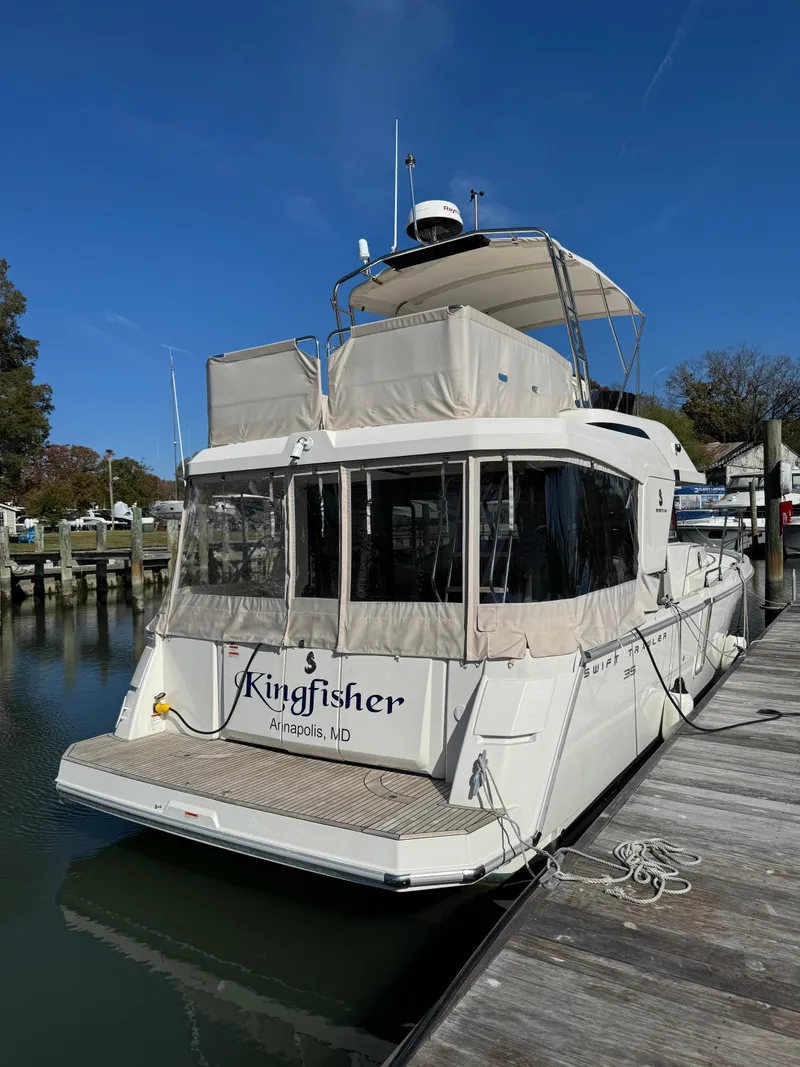 Slide: The Image of 2023 Beneteau Swift Trawler 35 docked, rear view, clear sky. - 2