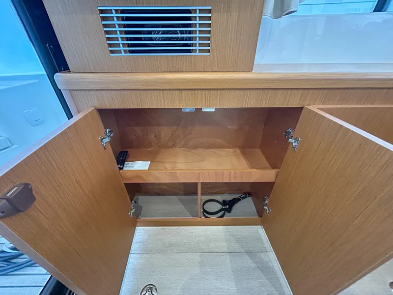 Slide: The Image of 2023 Beneteau Swift Trawler 35 interior cabinet with open wooden doors. - 20