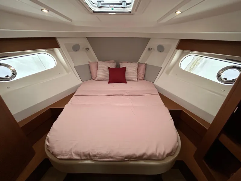 Slide: The Image of 2023 Beneteau Swift Trawler 35 cabin with cozy bed and porthole windows. - 21