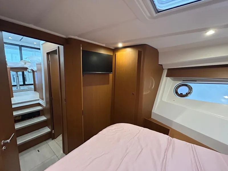 Slide: The Image of Interior of 2023 Beneteau Swift Trawler 35, featuring cozy cabin with TV and porthole. - 23