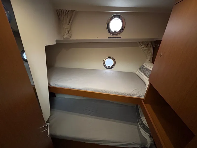 Slide: The Image of 2023 Beneteau Swift Trawler 35 cabin with bunk beds and portholes. - 24