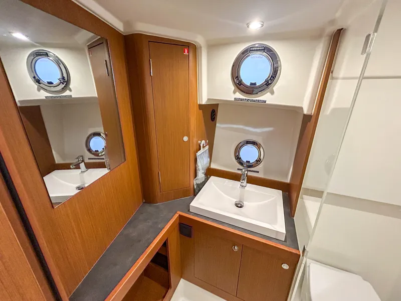 Slide: The Image of Luxurious bathroom in 2023 Beneteau Swift Trawler 35 with modern fixtures and porthole windows. - 25